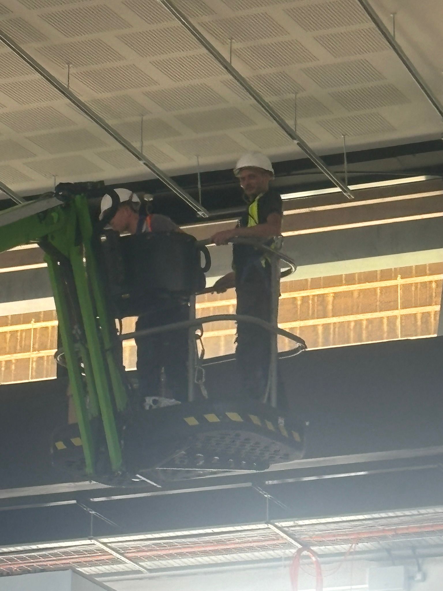 FLEX spray technicians on a cherry-picker spraying ceiling steelwork