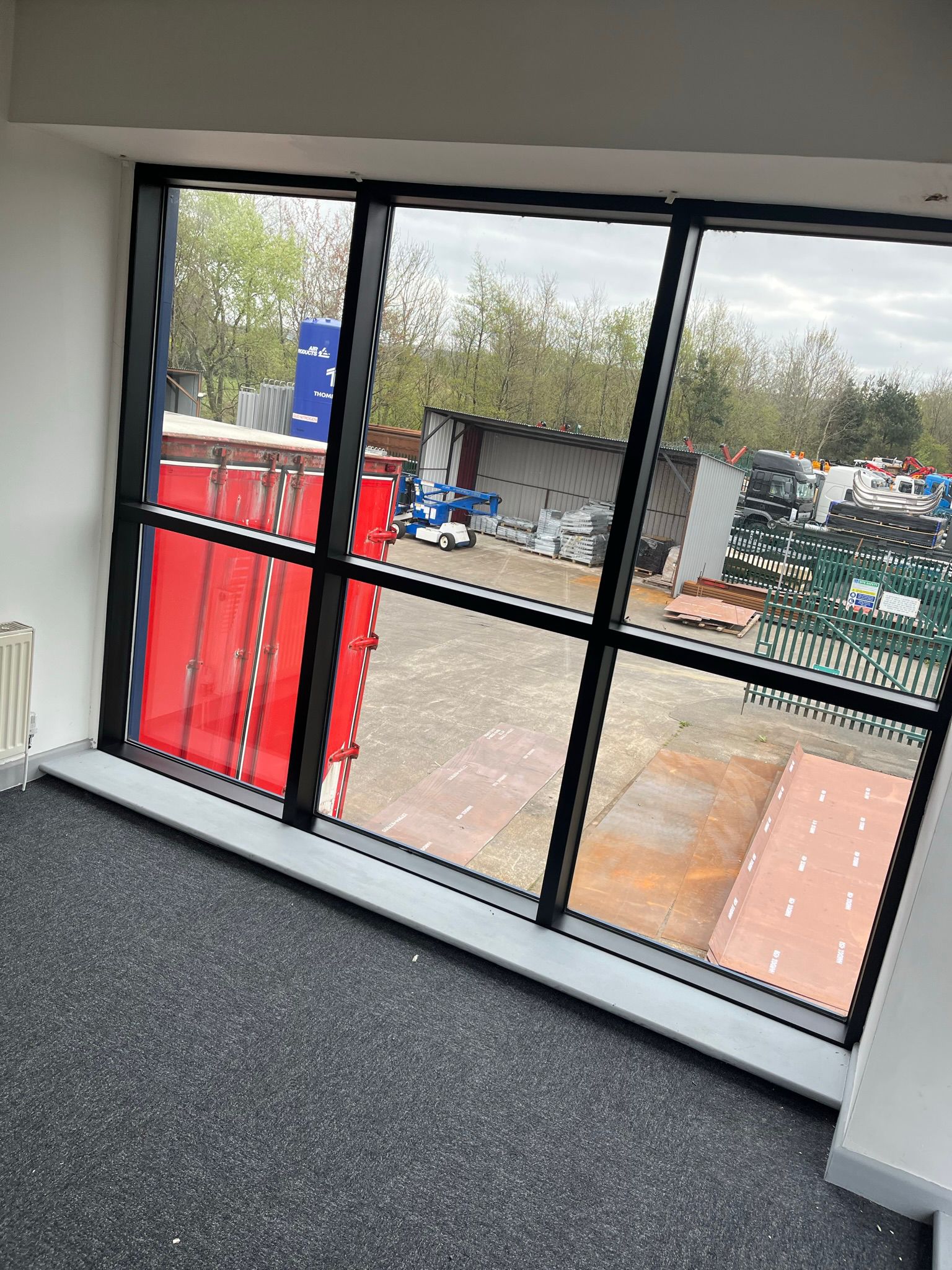 Black aluminium window frames and red doors in commercial fit-out
